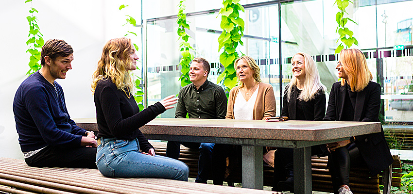 Studenter sitter vid ett bord i Gummifabriken och diskuterar.