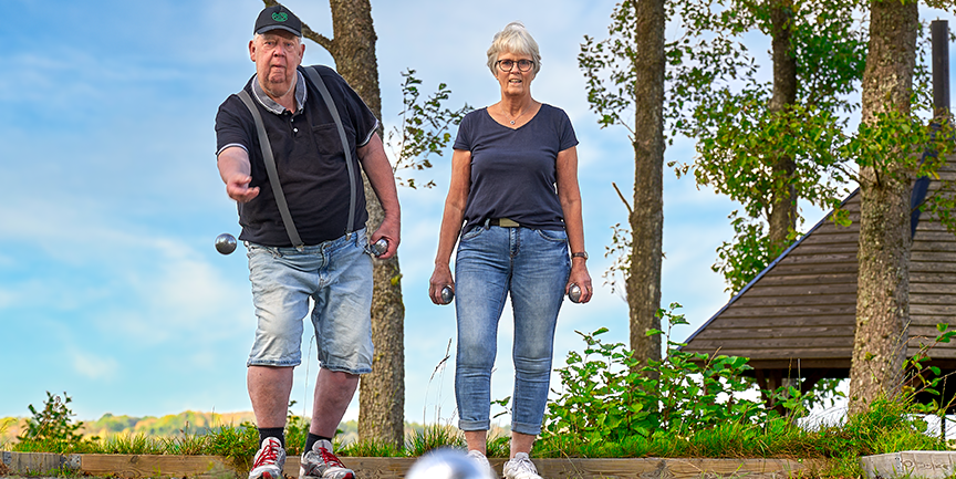Två äldre personer spelar boule.