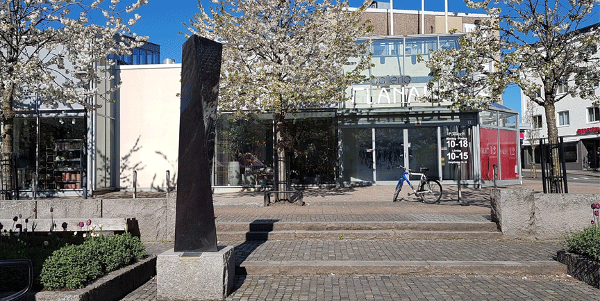 Flanaden med skulpturen Stigande spiral i förgrunden och blommande träd i bakgrunden.