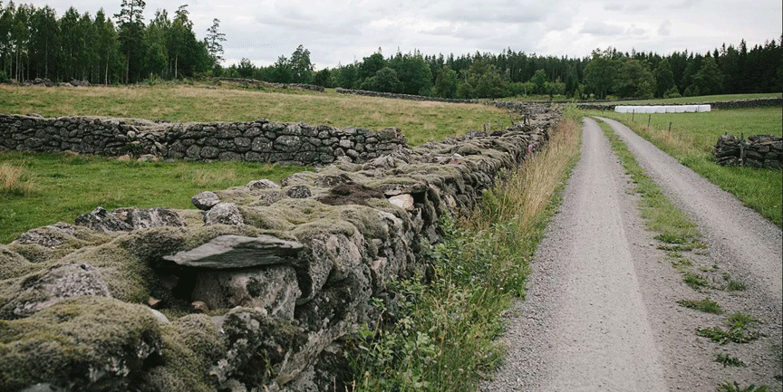 Stenmur i Stensöta med en grusväg bredvid.
