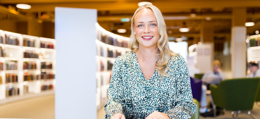 Glad student I biblioteket efter nya beviljade yrkeshögskoleutbildningar.