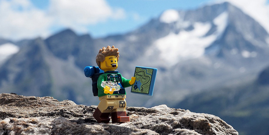 En lego-figur som bestiger ett berg.