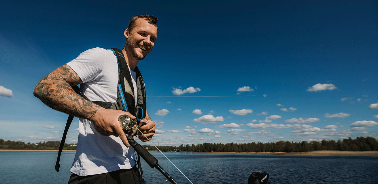 En glad ung kille fiskar i Vidöstern.