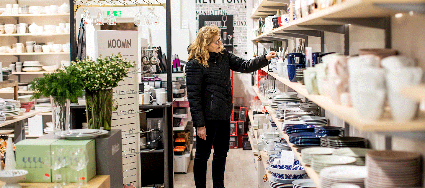 En kvinna kollar på inredningsartiklar i en butik.