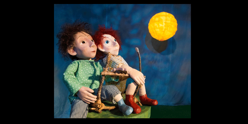 Två dockor som tittar upp mot månen.