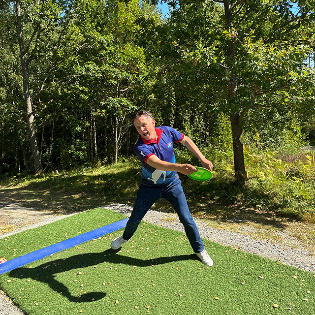 En man kastar discgolf
