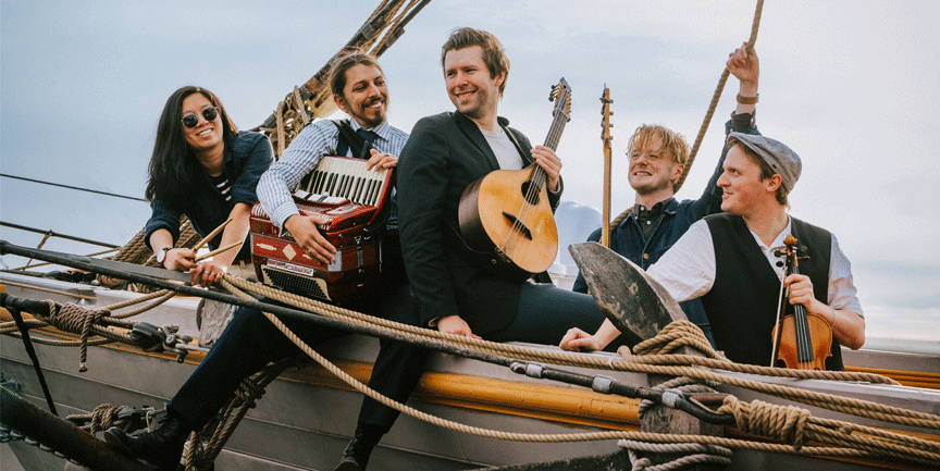 De fyra medlemmarna Kim Persson, Samuel Linderström, Tommy Lundgren och Johanna Gustafsson framför en tegelvägg.