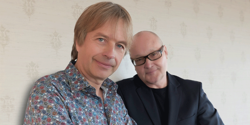 Nils Landgren och Jan Lundgren framför en grå vägg.