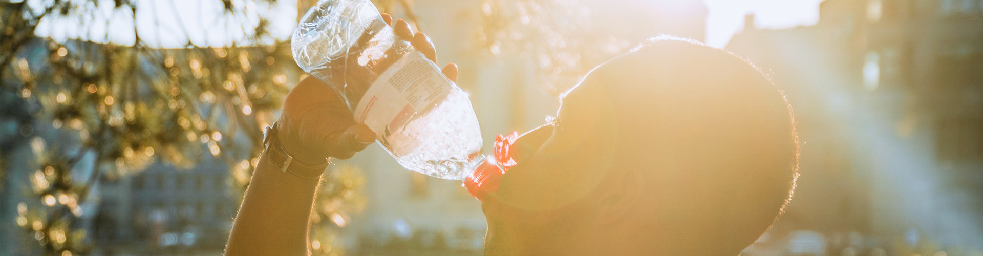 Bild på en person dricker vatten ur en plastflaska.