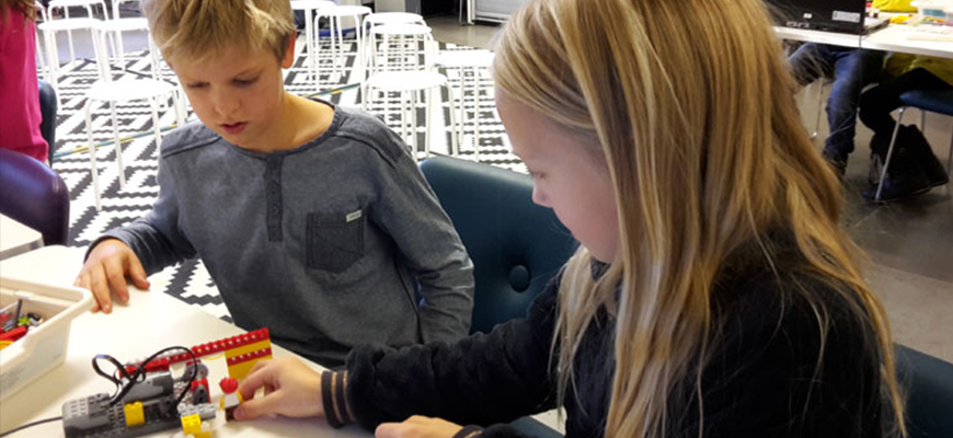 En pojke och en flicka konstruerar med Lego