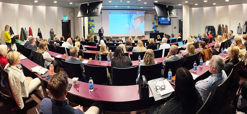 Tre personer ler in i kameran.