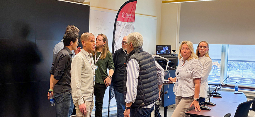 Tre personer ler in i kameran.