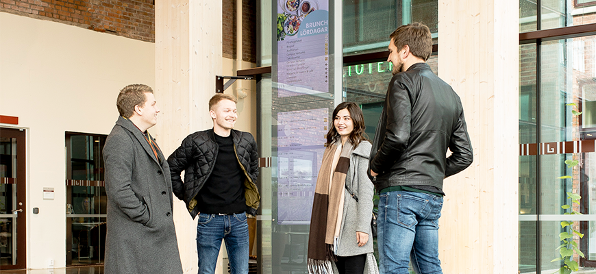 Några studenter samtalar vid entrén i Gummifabriken.