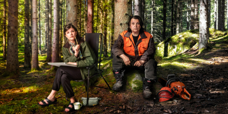 Två kvinnor som sitter ute i en skog.