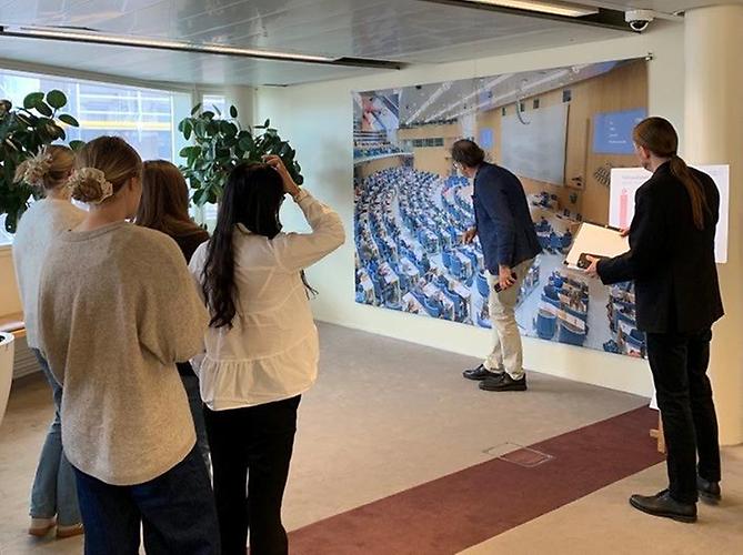 En man visar en bild på hur det ser i riksdagen