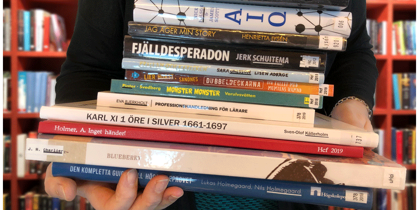 En person som håller i en hög med böcker.